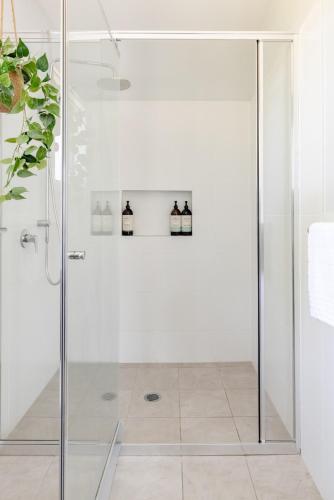 a shower with a glass door in a bathroom at Mala Retreat, Shiraz Suite 5 Star Immaculate and Comfortable in East Maitland