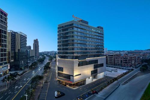 a tall building in a city with a street at Ramada by Wyndham Foshan Danzao in Huadu