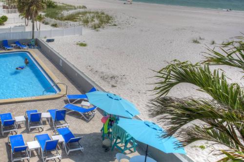 an overhead view of a pool and beach with chairs and umbrellas at 318 - Island Inn in St. Pete Beach