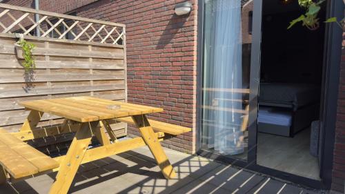 a wooden picnic table sitting on a patio at Hotel Emilia in Kaatsheuvel