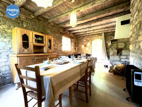 une salle à manger avec une longue table et des chaises dans l'établissement Pura Vida Maison Ardéchoise, à Rochecolombe