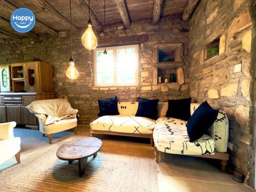 - un salon avec deux canapés et un mur en pierre dans l'établissement Pura Vida Maison Ardéchoise, à Rochecolombe