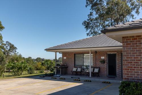 a brick house with a patio and a grill at Mala Retreat, Shiraz Suite 5 Star Immaculate and Comfortable in East Maitland