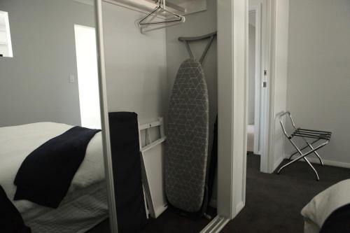 a bedroom with a bed and a mirror and a chair at Mala Retreat, Shiraz Suite 5 Star Immaculate and Comfortable in East Maitland