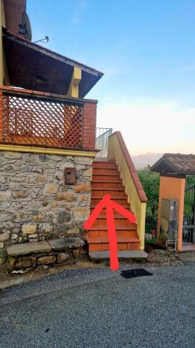 a red arrow on the steps of a house at La loggia sulle Apuane in Tresana