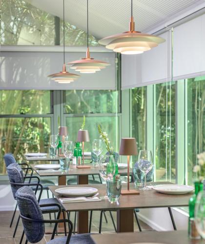 a dining room with tables and chairs and windows at Hotel Carmel  in Haifa