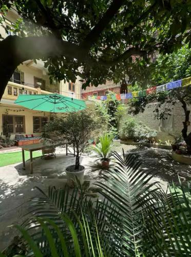 a courtyard with a bench and an umbrella at The Melo pomelo courtyard. ( Right in between Thamel and basantapur durbar square) in Kathmandu