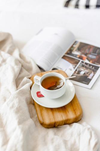 a cup of coffee on a plate on a tray on a bed at Mala Retreat Chardonnay Studio Immaculate and Comfortable in East Maitland