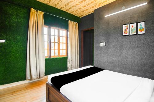 a bedroom with a bed and a green wall at Super Hotel O Champasari Siliguri formerly Four Fox Suits in Siliguri