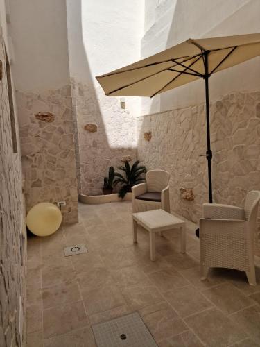 a room with a table and an umbrella and chairs at Home Belvedere in Brindisi