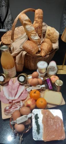 a table with bread and eggs and a basket of food at LA PETITE EVELETTE - Piscine et Sauna au Calme in Ohey