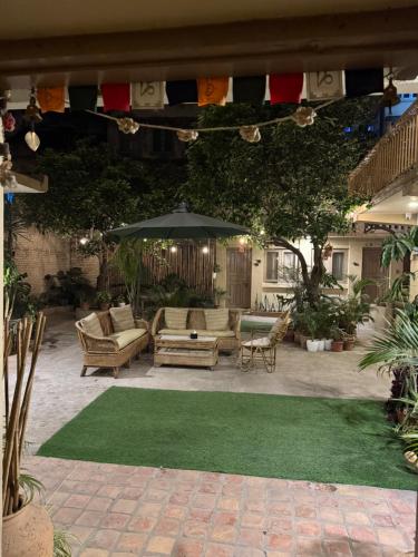a patio with chairs and an umbrella and grass at The Melo pomelo courtyard. ( Right in between Thamel and basantapur durbar square) in Kathmandu