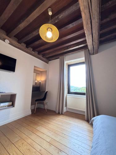 a bedroom with a bed and a window and a chair at domaine du vernay in Mazille