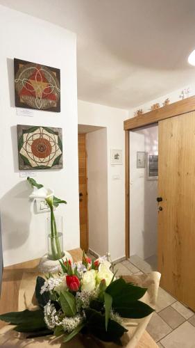 a vase of flowers on a table in a room at Hiša Manira in Ajdovščina