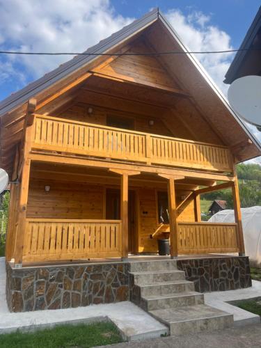 a log cabin with stairs in front of a house at Apartman za porodicu in Mokra Gora