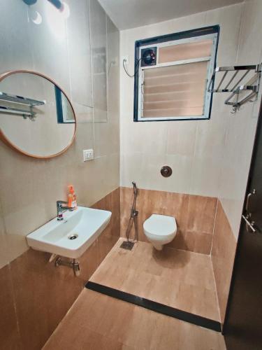 a bathroom with a sink and a mirror and a toilet at Cinnamon Stays Benaulim in Benaulim