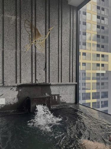 a bird sculpture on the side of a building with water at Lynn Times Thanh Thuỷ hotspring-KS 35 tầng- My Home in Phú Thọ