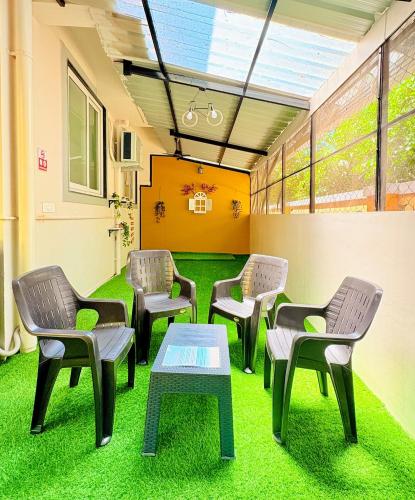 a waiting room with chairs and a table on grass at Cinnamon Stays Benaulim in Benaulim