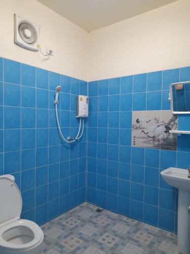 a blue tiled bathroom with a shower and a toilet at Jayzada Fang Resort เจซาด้า รีสอร์ท in Fang