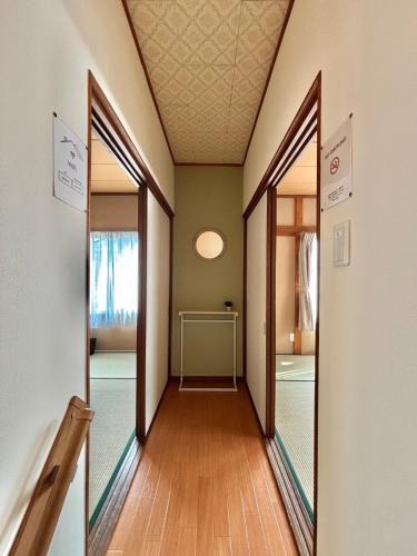 an empty hallway with two doors and a mirror at 最大9名可 無料駐車場付 和モダン1棟貸切 4独立寝室 乾燥機付 in Gifu