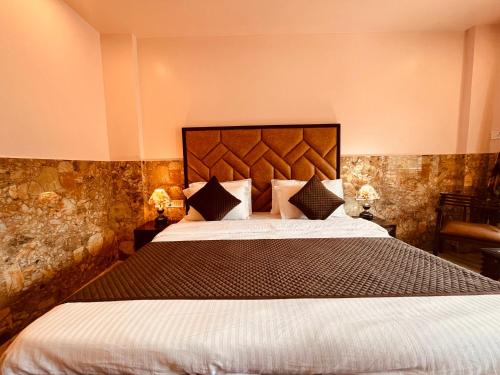 a bedroom with a large bed and two lamps at River Grand Resort - A Peaceful Stay Kempty Fall Mussoorie by Sitara Group in Mussoorie