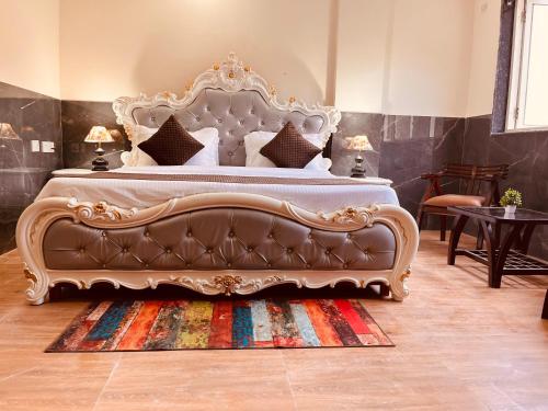 a bedroom with a large bed with a couch at River Grand Resort - A Peaceful Stay Kempty Fall Mussoorie by Sitara Group in Mussoorie