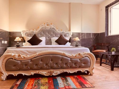 a bedroom with a large bed with a leather couch at River Grand Resort - A Peaceful Stay Kempty Fall Mussoorie by Sitara Group in Mussoorie
