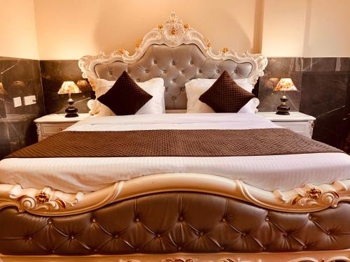 a bedroom with a large bed with a large headboard at River Grand Resort - A Peaceful Stay Kempty Fall Mussoorie by Sitara Group in Mussoorie
