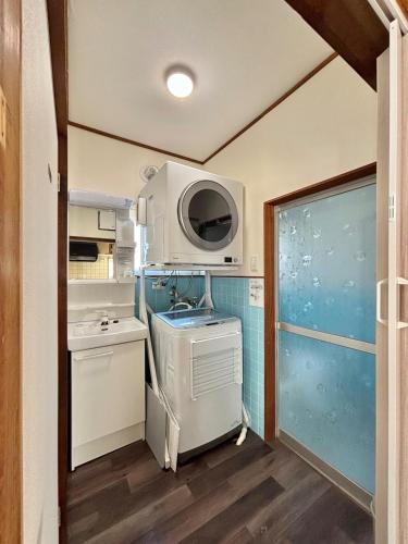 a small kitchen with a sink and a microwave at 最大9名可 無料駐車場付 和モダン1棟貸切 4独立寝室 乾燥機付 in Gifu