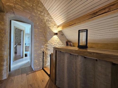 a room with a stone wall and a wooden counter at Les Peupliers in Noyers-sur-Cher