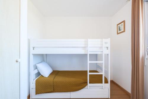 Appartement aux Cottages du Lac H70 في بارينتس إن بورن: سرير بطابقين أبيض مع سلم في الغرفة