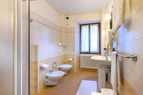 a bathroom with two toilets and a sink at Hotel Garni Le Corti in Grosotto