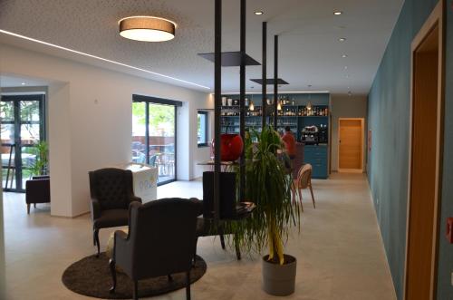 a lobby with a table and chairs and a pharmacy at Parkhotel Zur Linde in Silandro
