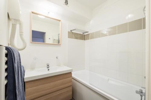 Appartement aux Cottages du Lac H70 في بارينتس إن بورن: حمام مع حوض وحوض استحمام ومرآة