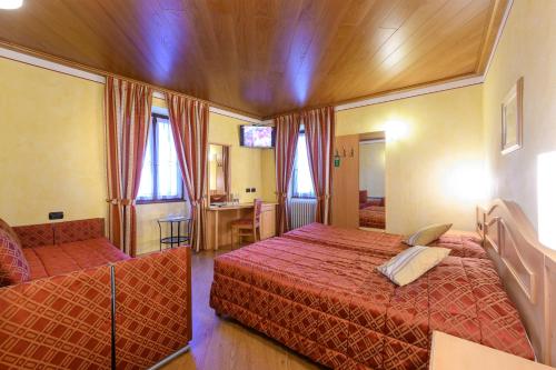 a hotel room with two beds and a kitchen at Hotel Garni Le Corti in Grosotto