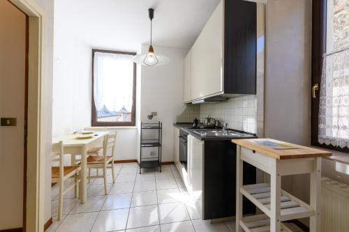 a kitchen with a sink and a table in it at Hotel Garni Le Corti in Grosotto