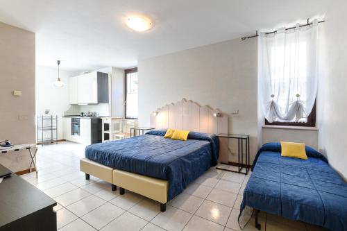 a bedroom with two beds and a kitchen at Hotel Garni Le Corti in Grosotto