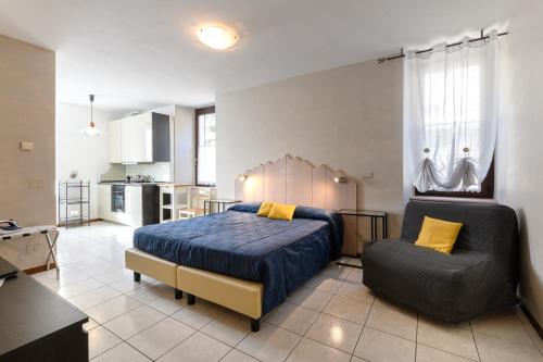 a bedroom with a bed and a chair in it at Hotel Garni Le Corti in Grosotto
