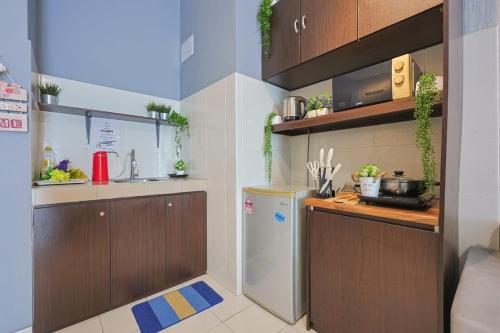 a kitchen with brown cabinets and a refrigerator at 5mins to Sunway Pyramid #Subang SS15 Cozy Studio Menara Rajawali in Subang Jaya