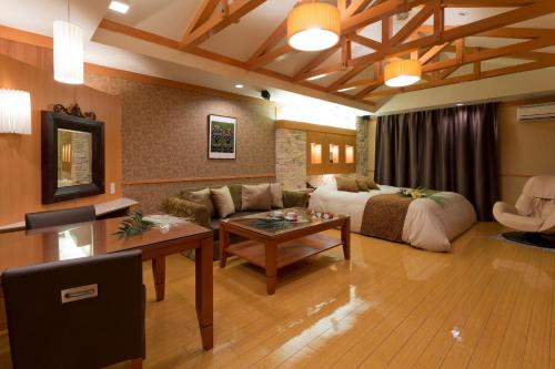 a living room with a bed and a couch at ホテルベノアリゾート in Kobe