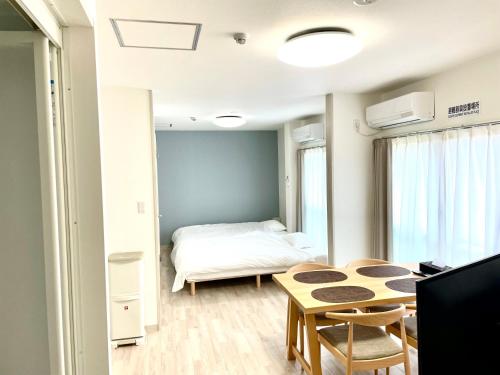 una piccola stanza con un letto e un tavolo di Villa Hayabusa ad Osaka