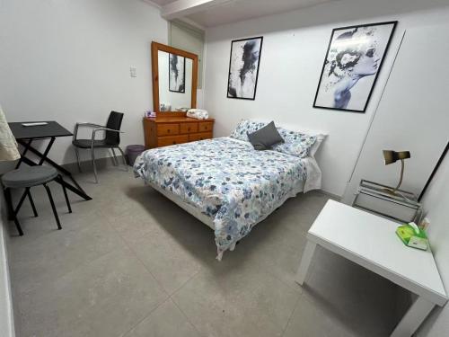 a bedroom with a bed and a table and a desk at Rest & Relax Units in Whangarei