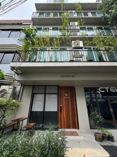a building with a wooden door and a balcony at Rimm49 Bangkok in Bangkok