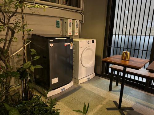a dryer and a washing machine sitting next to a table at Rimm49 Bangkok in Bangkok