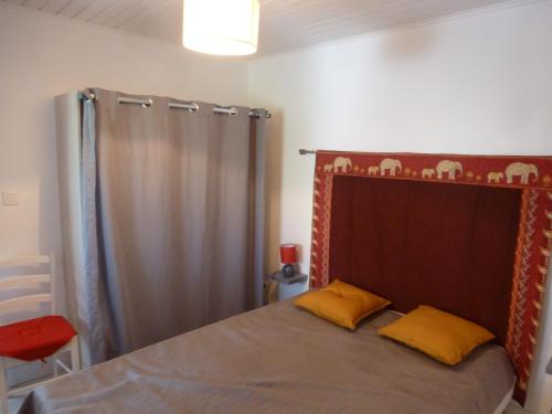 - un lit avec 2 oreillers jaunes dans une chambre dans l'établissement maisonnette entre plage et port, à Pornic