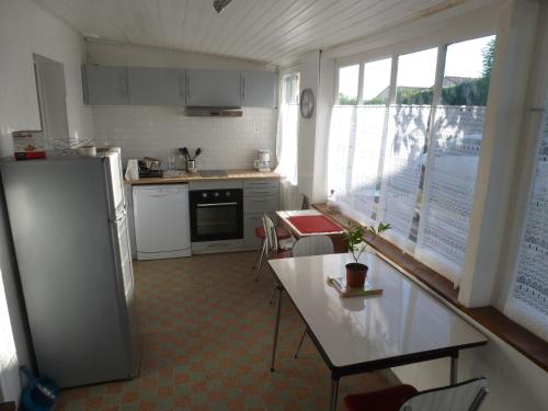une cuisine avec un réfrigérateur et une table à l'intérieur dans l'établissement maisonnette entre plage et port, à Pornic
