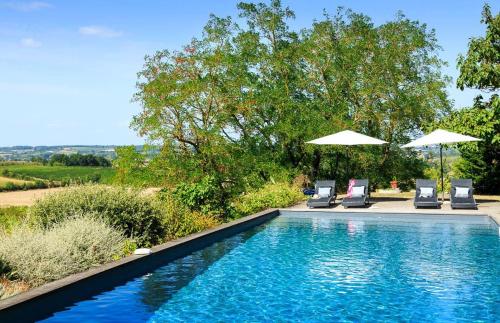 - une piscine avec 2 chaises longues et 2 parasols dans l'établissement OSHIDORi le Petit Manoir, à Monteton