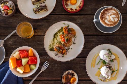 a table with plates of food and a cup of coffee at Peppers Beach Club & Spa in Palm Cove