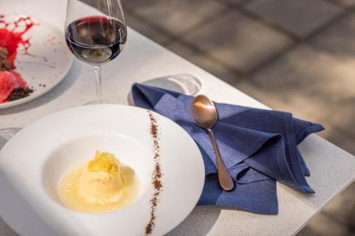 a white plate of food and a glass of wine at Peppers Beach Club & Spa in Palm Cove