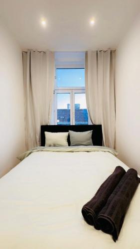 a bedroom with a large white bed with a window at Comfy & Cozy 4BR Shared Apt next to Kaufpark Alterlaa in Vienna